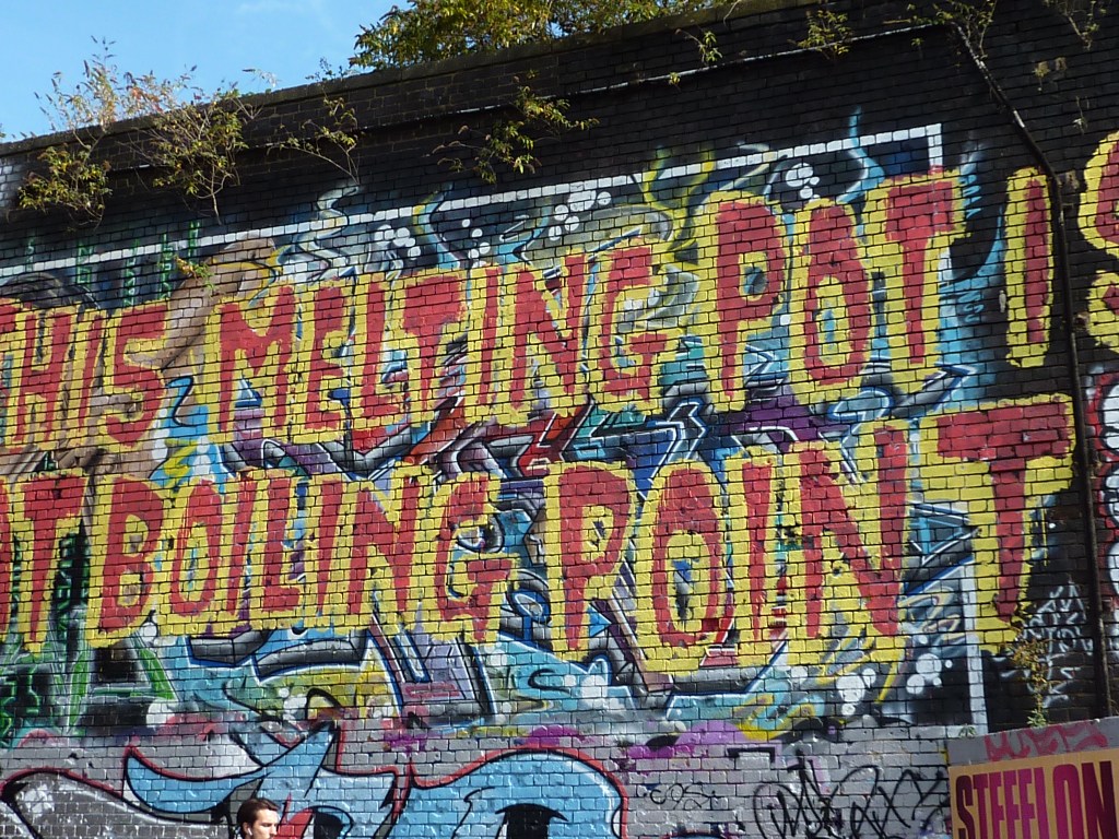 huge graffiti on a brick wall spelling out 'this melting pot is reaching boiling point'